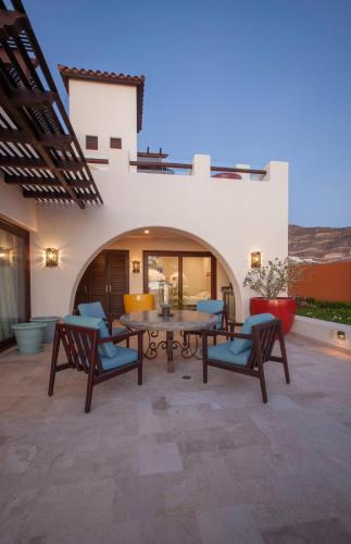 a patio with a wooden table and chairs at Playa de La Paz 3 BR Condo Access to Beach club in La Paz