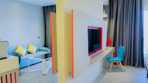 a living room with a blue couch and a tv at ibis Styles Kota Bharu in Kota Bharu