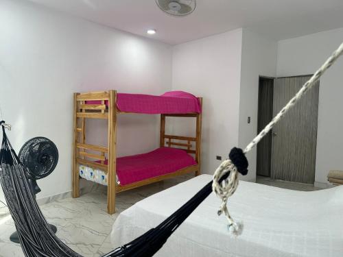 a bedroom with a bed and a red chair at Cabaña Maríamar2 in Puerto Escondido