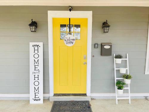 a yellow door on a house with a sign on it at Spacious home, 3 king beds, huge backyard near UM in Memphis