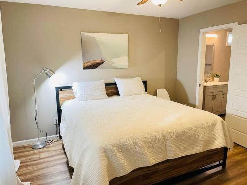 a bedroom with a large bed with a white bedspread at Spacious home, 3 king beds, huge backyard near UM in Memphis