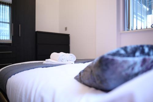 a bedroom with a bed with towels on it at Leeds City Centre Apartment in Leeds