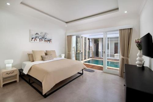 a bedroom with a bed and a swimming pool at Villa Bella Rose Canggu in Canggu