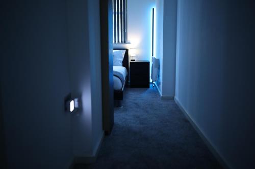 um quarto escuro com uma cama e uma janela em Leeds City Centre Apartment em Leeds