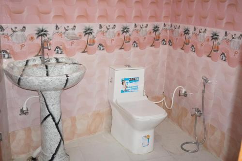a pink bathroom with a sink and a toilet at Shree Radha Rani Dham, Near Iskcon and Prem Mandir in Vrindāvan