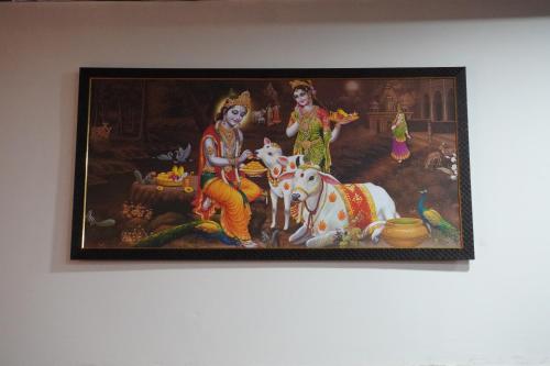 a painting of two women with a cow on a wall at Shree Radha Rani Dham, Near Iskcon and Prem Mandir in Vrindāvan