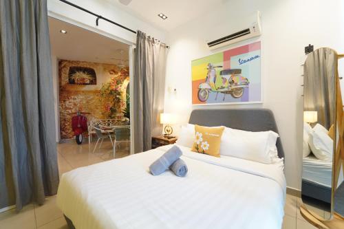 a bedroom with a white bed and a living room at 家 Majestic Ipoh in Ipoh