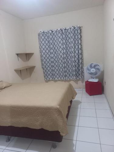sypialnia z łóżkiem i oknem z wentylatorem w obiekcie Apto Aconchegante em Fortaleza-CE w mieście Fortaleza