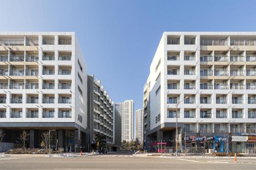 two tall white buildings next to a street at Urbanstay Sokcho Beach AB in Sokcho