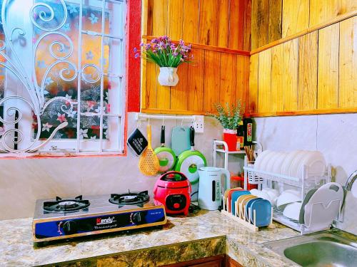 a kitchen counter with a stove and a sink at WIND HILL HOMESTAY HÀ GIANG in Làng Me