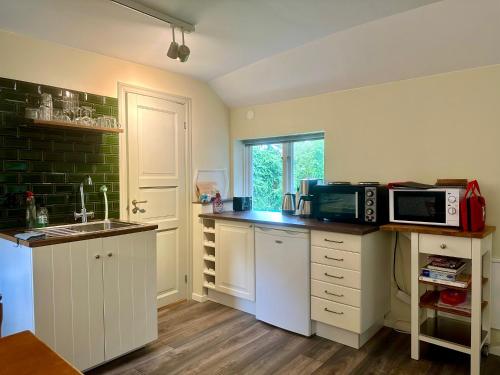 a kitchen with a sink and a microwave oven at Lyrkroken in Vittsjö