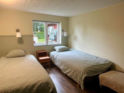 een slaapkamer met 2 bedden en een raam bij Lyrkroken in Vittsjö