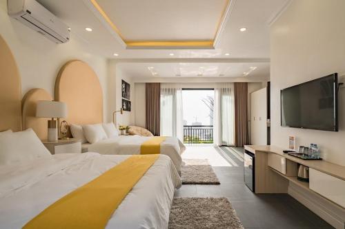a hotel room with two beds and a flat screen tv at Orestay Garden Hạ Long in Ha Long