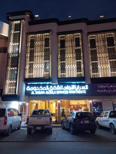 un bâtiment avec des voitures garées devant lui dans l'établissement السرايا الاولى للشقق المخدومة, à Al Hofuf