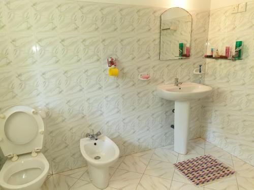 a white bathroom with a toilet and a sink at Mohotti House in Galle