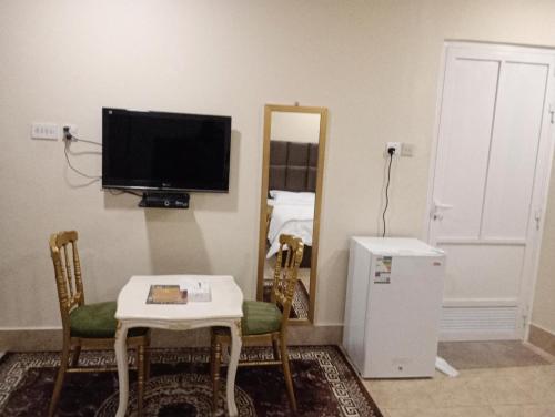 ein Wohnzimmer mit einem kleinen Tisch und einem TV in der Unterkunft السرايا الاولى للشقق المخدومة in Al Hofuf