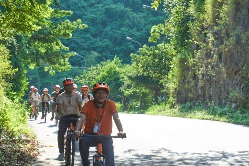a group of people riding bikes down a road at Hanoi EcoStay 2 hostel in Hanoi