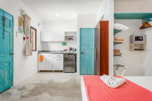 una pequeña cocina con una cama roja en una habitación en Casa Toloc Tulum en Tulum