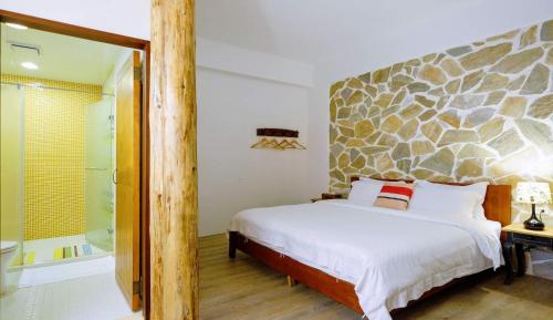 a bedroom with a bed and a walk in shower at Shire Homestay in Luodong