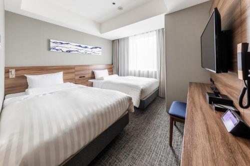 a hotel room with two beds and a flat screen tv at Far East Village Hotel Tokyo Ariake in Tokyo