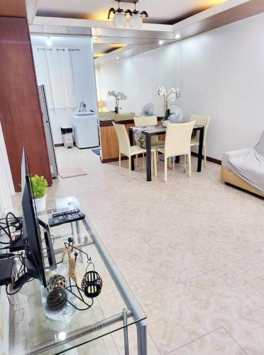 a living room and dining room with a glass table at Cozy 2BR with FREE Pool beside SM City Mall in Davao City