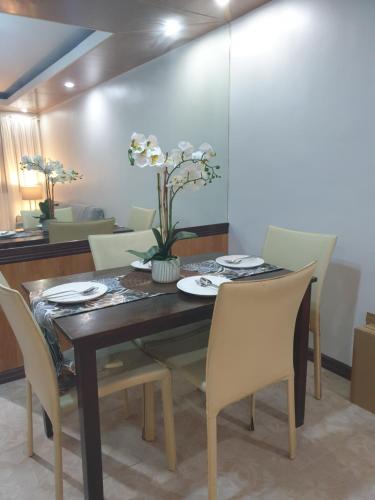 a dining room with a wooden table and chairs at Cozy 2BR with FREE Pool beside SM City Mall in Davao City