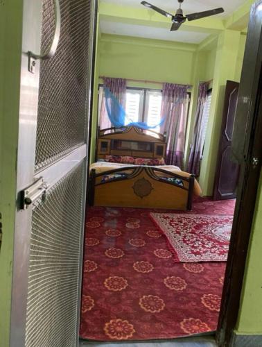 1 dormitorio con cama, ventana y puerta en pujan's homestay, en Bharatpur