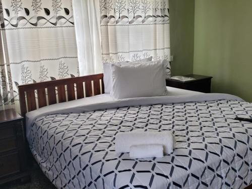 a bedroom with a large bed with two towels on it at Casa Consuelo Guest House in Takoradi