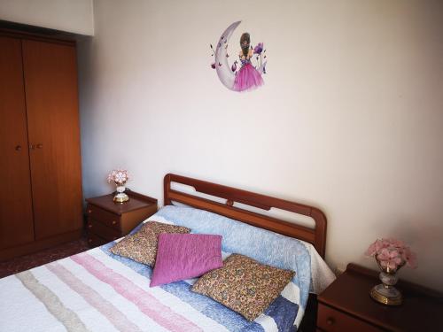 a bedroom with a bed with two night stands and a clock at Ca la conxita in Tona