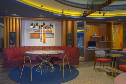 a living room with a red couch and a table and chairs at Four Points Flex by Sheraton Bursa Nilüfer in Bursa