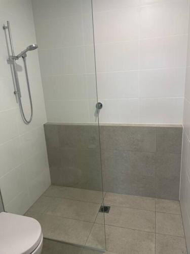 a bathroom with a shower and a toilet at Pandanus Paradise. Newly renovated 4 bedroom home in Cabarita Beach