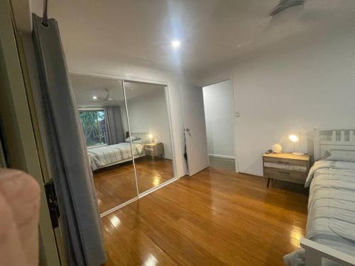 a room with a mirror and a bedroom with a bed at Pandanus Paradise. Newly renovated 4 bedroom home in Cabarita Beach