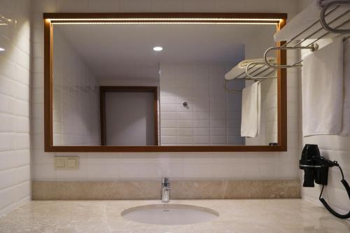 a bathroom with a sink and a large mirror at Four Points Express by Sheraton Bursa Nilufer in Bursa