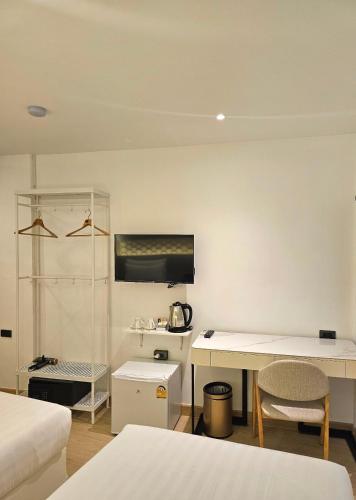 a room with two beds and a table and a desk at Arawana Express Sukhumvit 22 in Bangkok