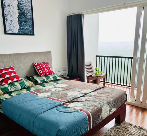 a bedroom with a large bed with a balcony at Mountain View Villa in Mukkam