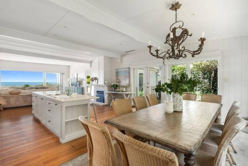 a kitchen and dining room with a table and chairs at Luxury Beach House Retreat Beach in Whale Beach