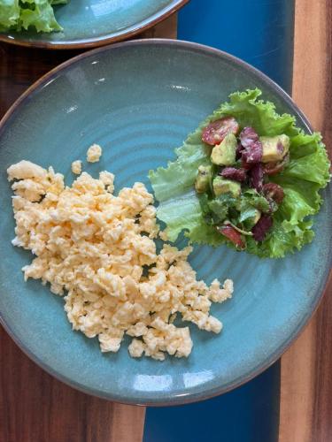 een blauw bord met eten, salade en rijst bij Le Rivage Villa Hoi An (Beach Front) in Hà Quảng (1)