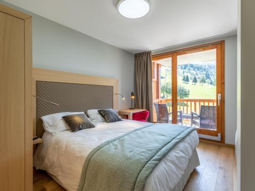 a bedroom with a bed and a large window at Appartement Les Arcs 1800, 4 pièces, 6 personnes - FR-1-352-57 in Arc 1800