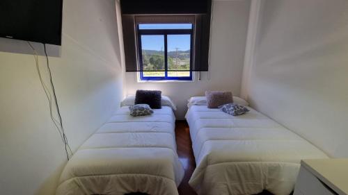 Cette chambre comprend 4 lits et une fenêtre. dans l'établissement Piso con terraza en Villagarcia de Arosa, à Vilagarcía de Arousa