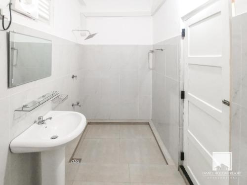 阿努拉德普勒的住宿－Family Holiday Resort，白色的浴室设有水槽和淋浴。