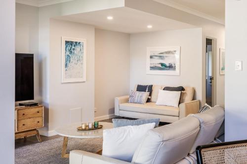 a living room with a couch and a tv at 10 Steps in Yallingup