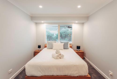 a bedroom with a white bed with two towels on it at 10 Steps in Yallingup