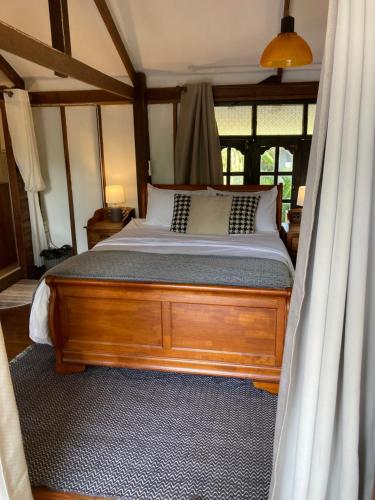 - une chambre avec un lit doté d'un cadre en bois dans l'établissement Up The Farm Udon Thani Farm Stay, 