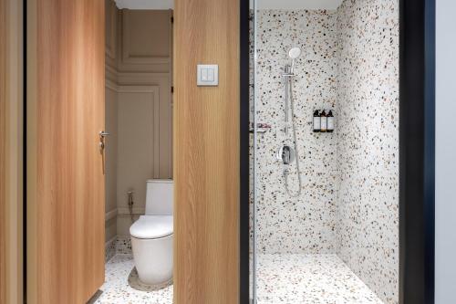 a bathroom with a toilet and a shower at Mercure Bangkok Surawong in Bangkok