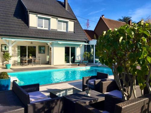 a home with a swimming pool with chairs and a house at Maison de 3 chambres avec piscine privee jacuzzi et wifi a Walbach in Walbach