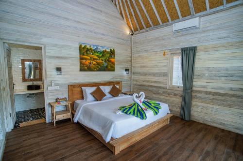 um quarto com uma cama num quarto com paredes de madeira em Blue Sky Villa Ceningan em Nusa Lembongan