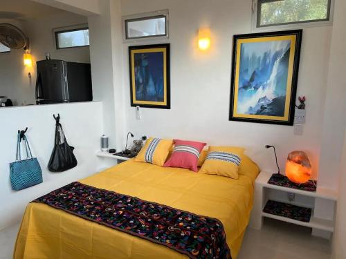 ein Schlafzimmer mit einem gelben Bett in einem Zimmer in der Unterkunft Amarilla (Amar y ya) in Cuatunalco