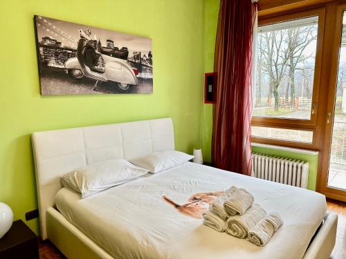 a bedroom with a white bed with a picture of a car at Natura e Golf con giardino privato in Fiano