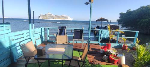 a cruise ship on the water with a deck with chairs at Hotel Victoria s Beach House in Roatan