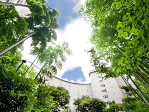 a white building with trees in front of it at The Prince Kyoto Takaragaike, Autograph Collection in Kyoto
